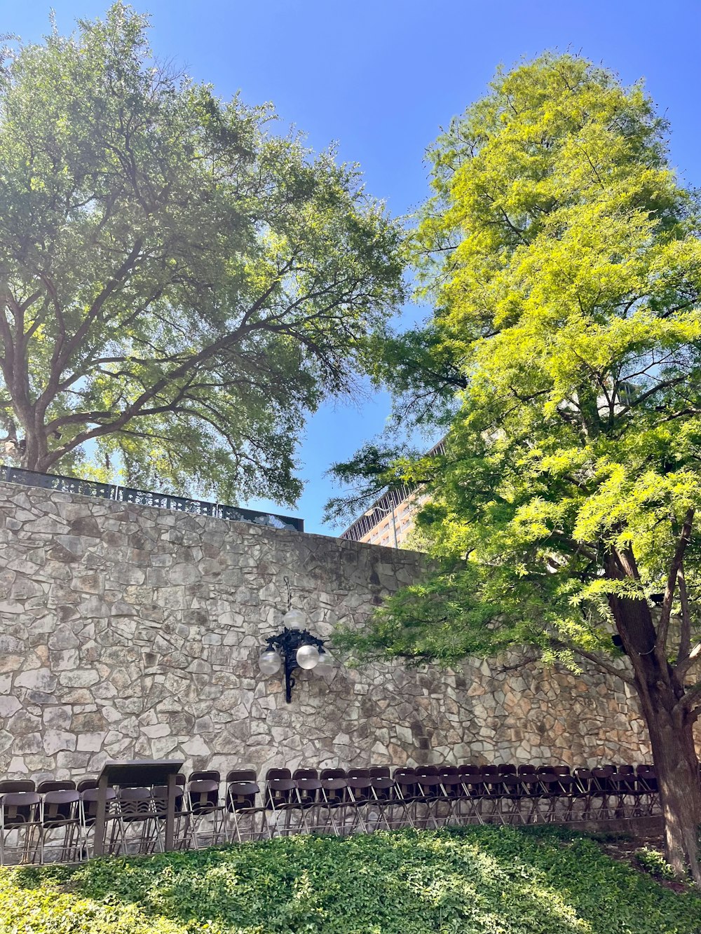 a stone wall with a bunch of chairs in front of it