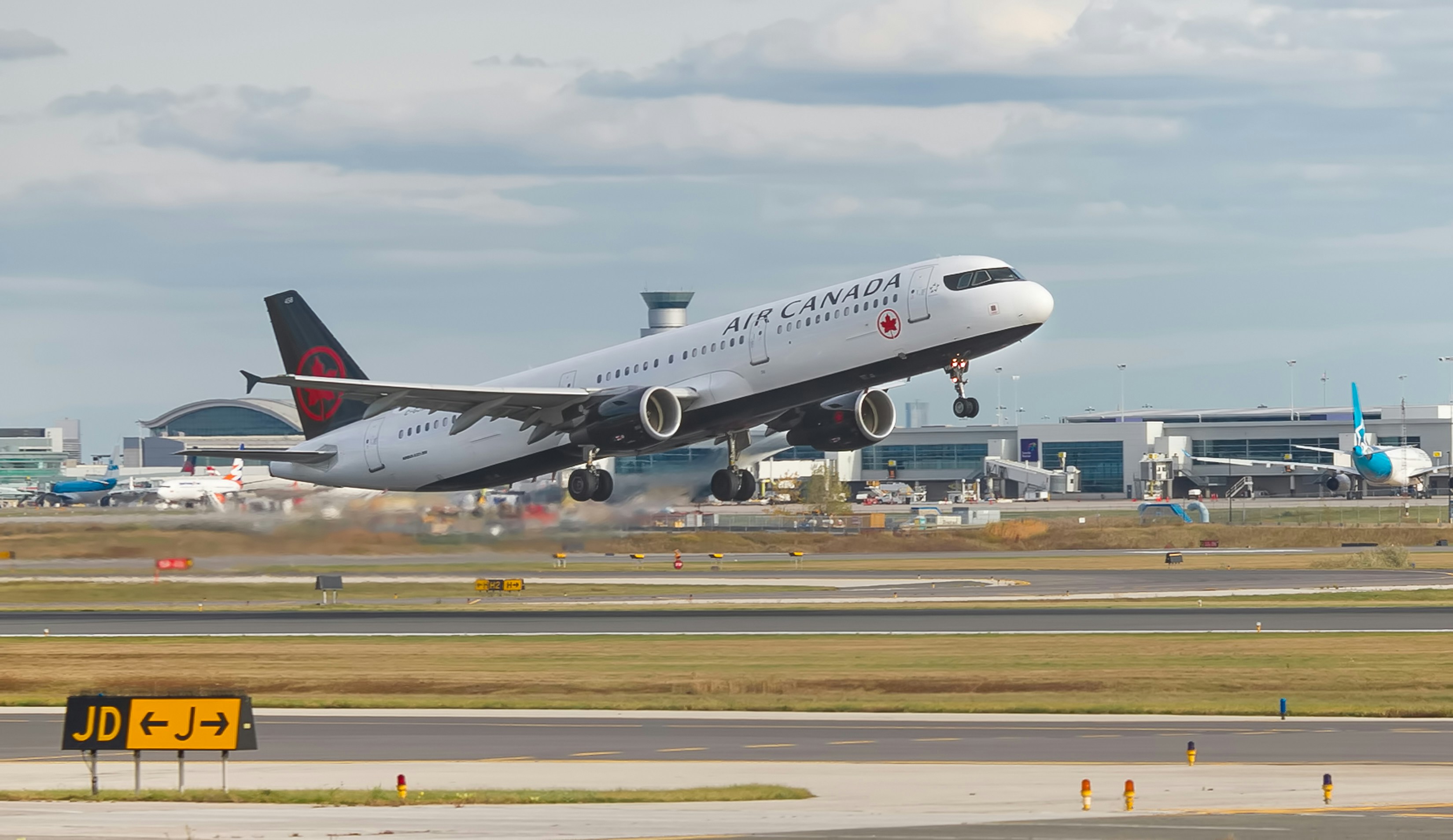 An Air Canada jetliner taking off from an airport runway.