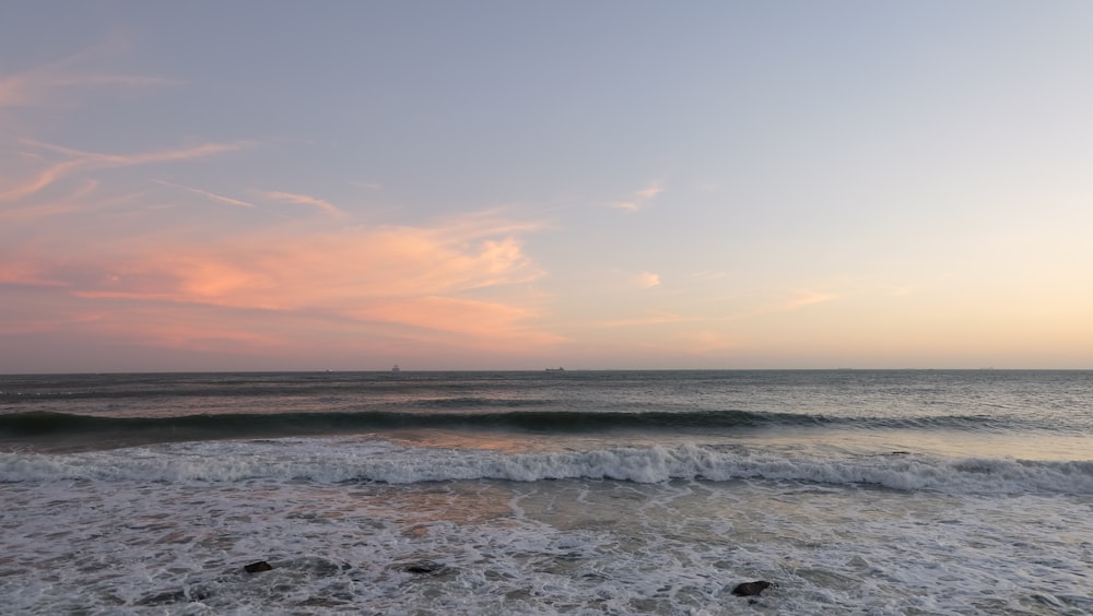 a view of the ocean from the shore at sunset