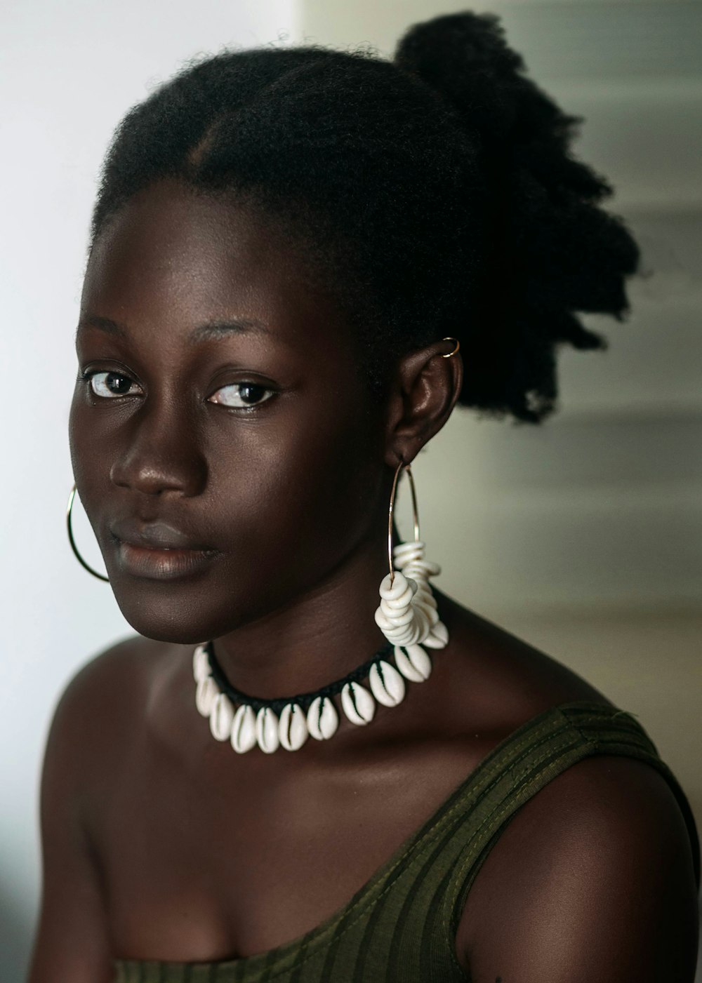 a woman with a necklace and earrings on her neck