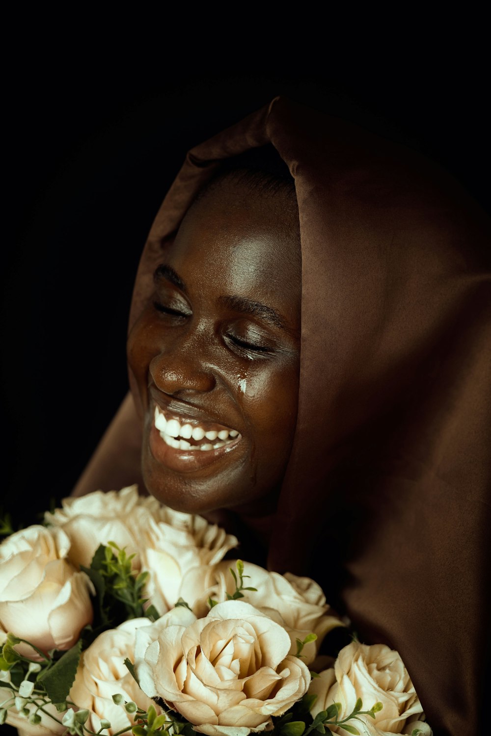 a woman in a brown dress holding a bouquet of flowers