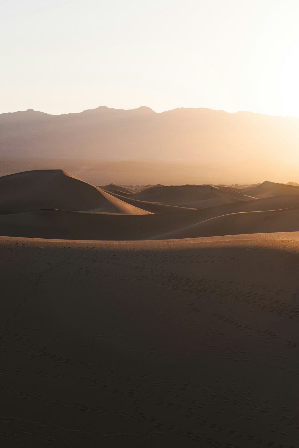 the sun is setting over the sand dunes