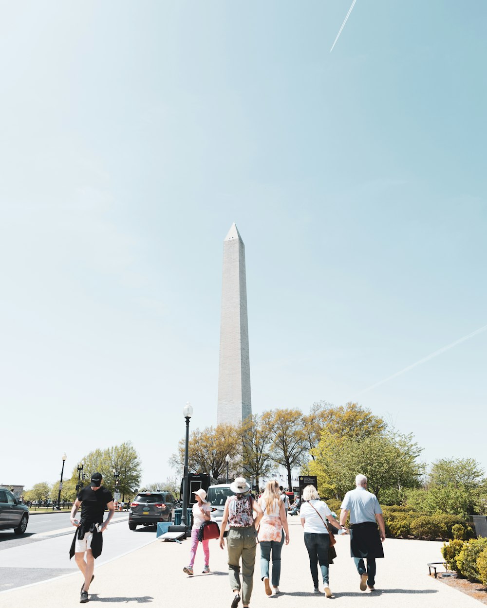 a group of people walking in front of the washington monument