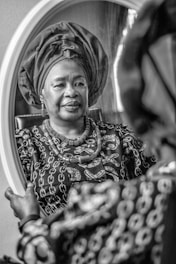 a woman in a turban looking in a mirror