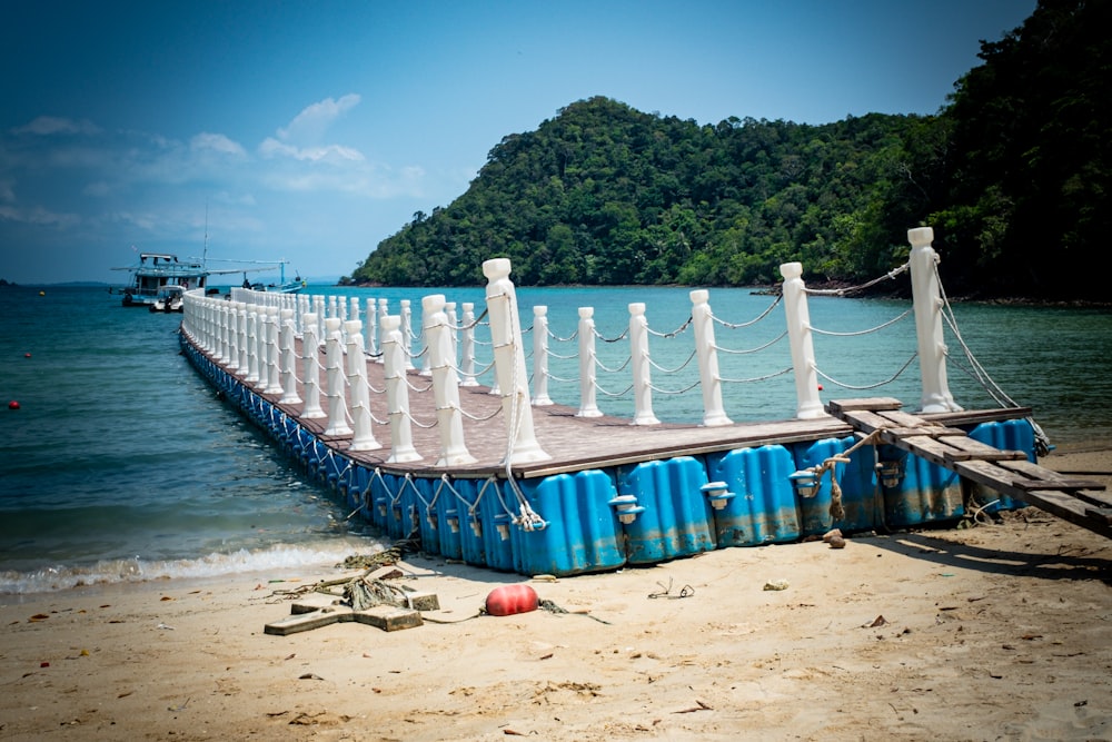 a boat sitting on top of a sandy beach next to the ocean