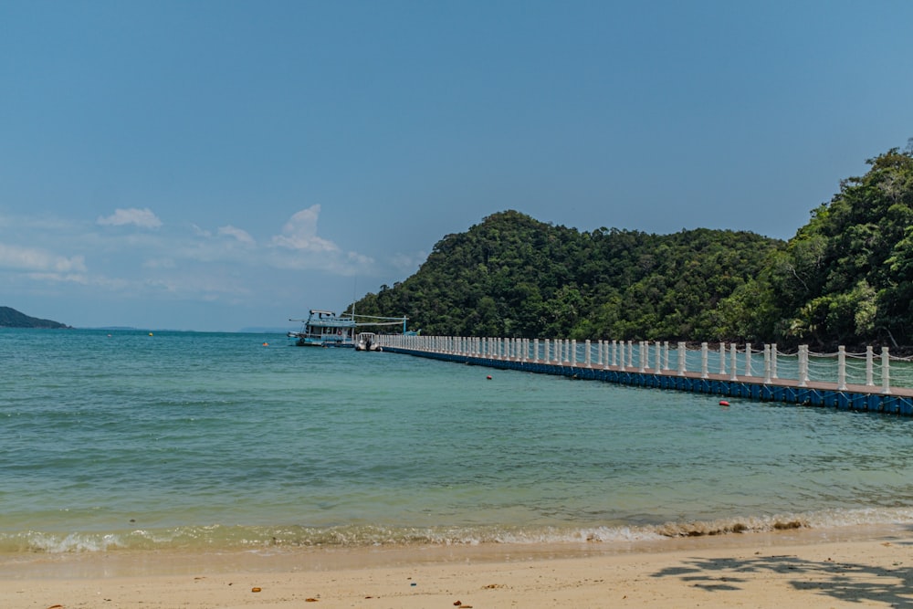 a long pier stretches out into the ocean