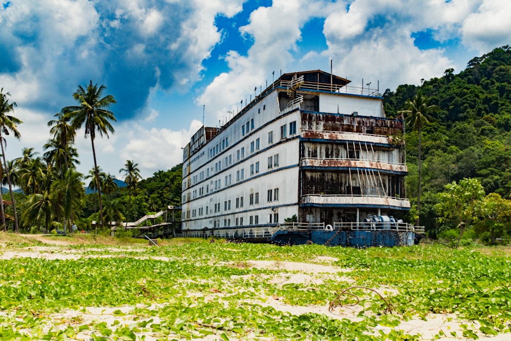 a large white building sitting on top of a lush green field