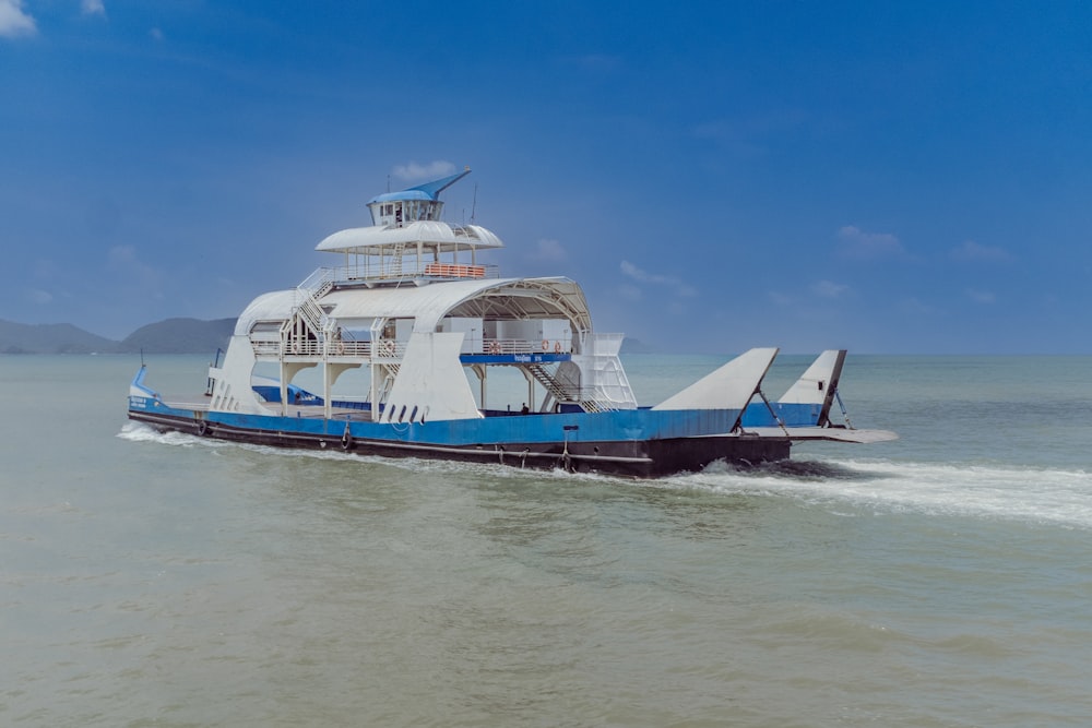 a blue and white boat traveling across a large body of water