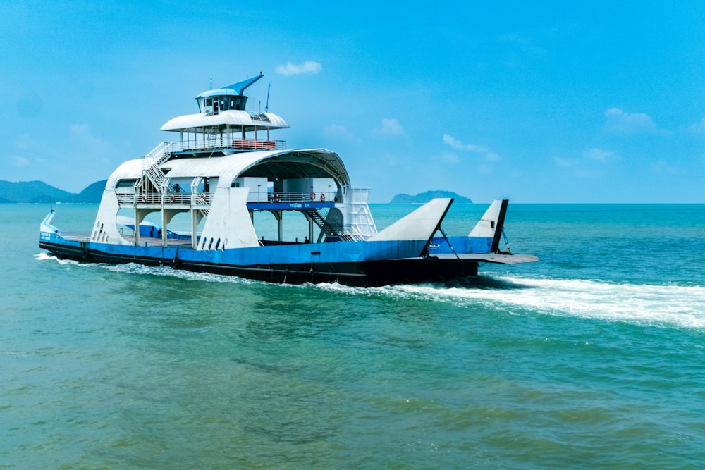 a blue and white boat in the middle of the ocean