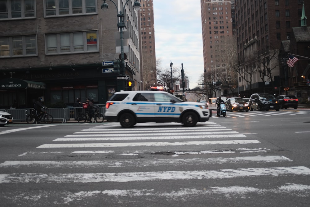 a police car driving down a street next to tall buildings