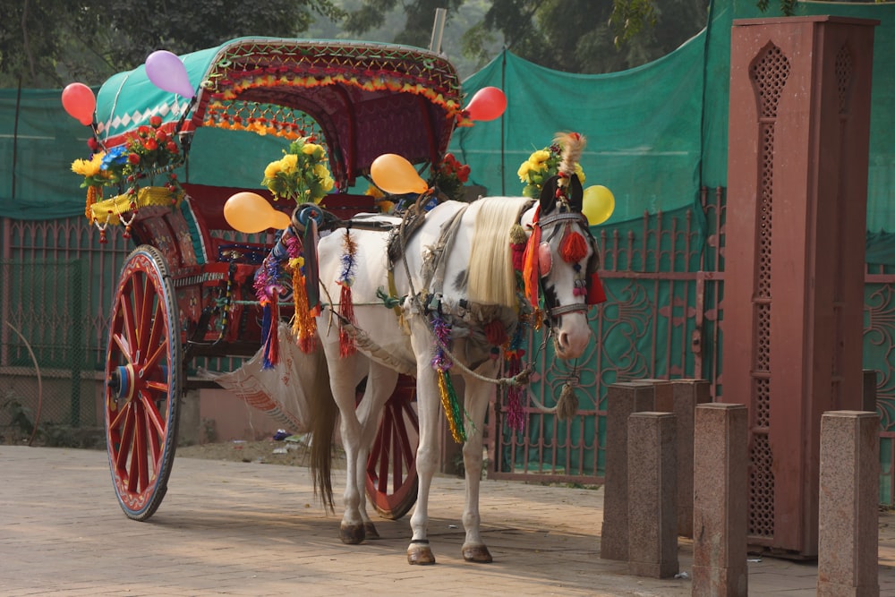 a white horse pulling a carriage with balloons on it