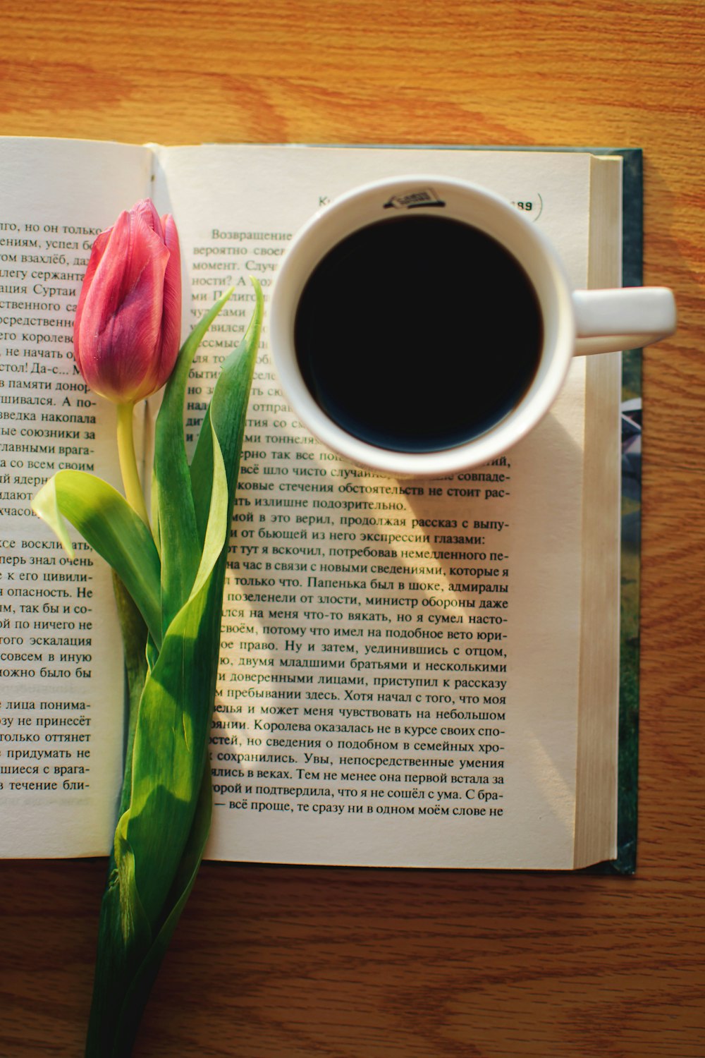a cup of coffee and a flower on a book