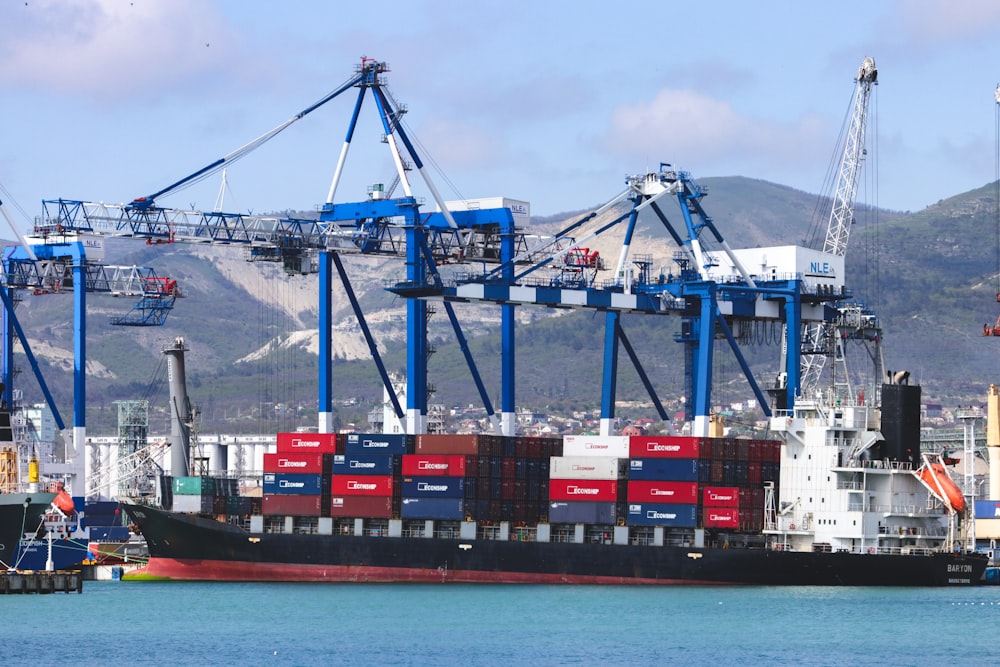 a large cargo ship in the water with a mountain in the background