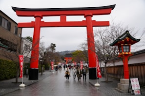 a group of people walking under a red tori tori tori tori tori tori tori tori