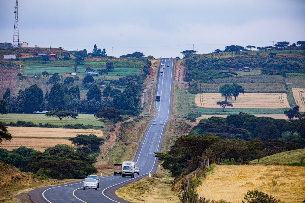 two cars driving down a road in the country