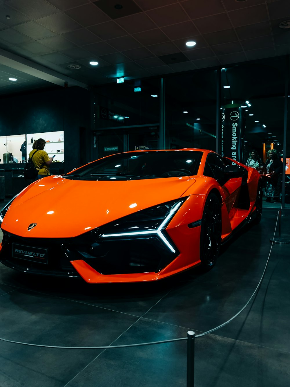 an orange sports car is on display in a showroom