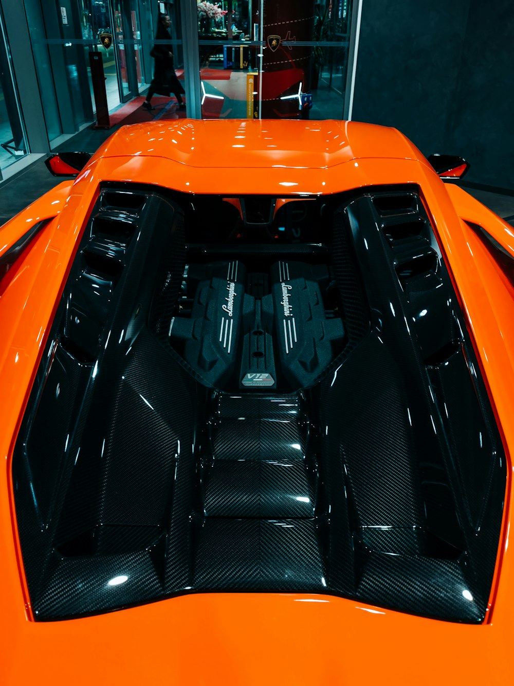 a close up of the hood of an orange sports car