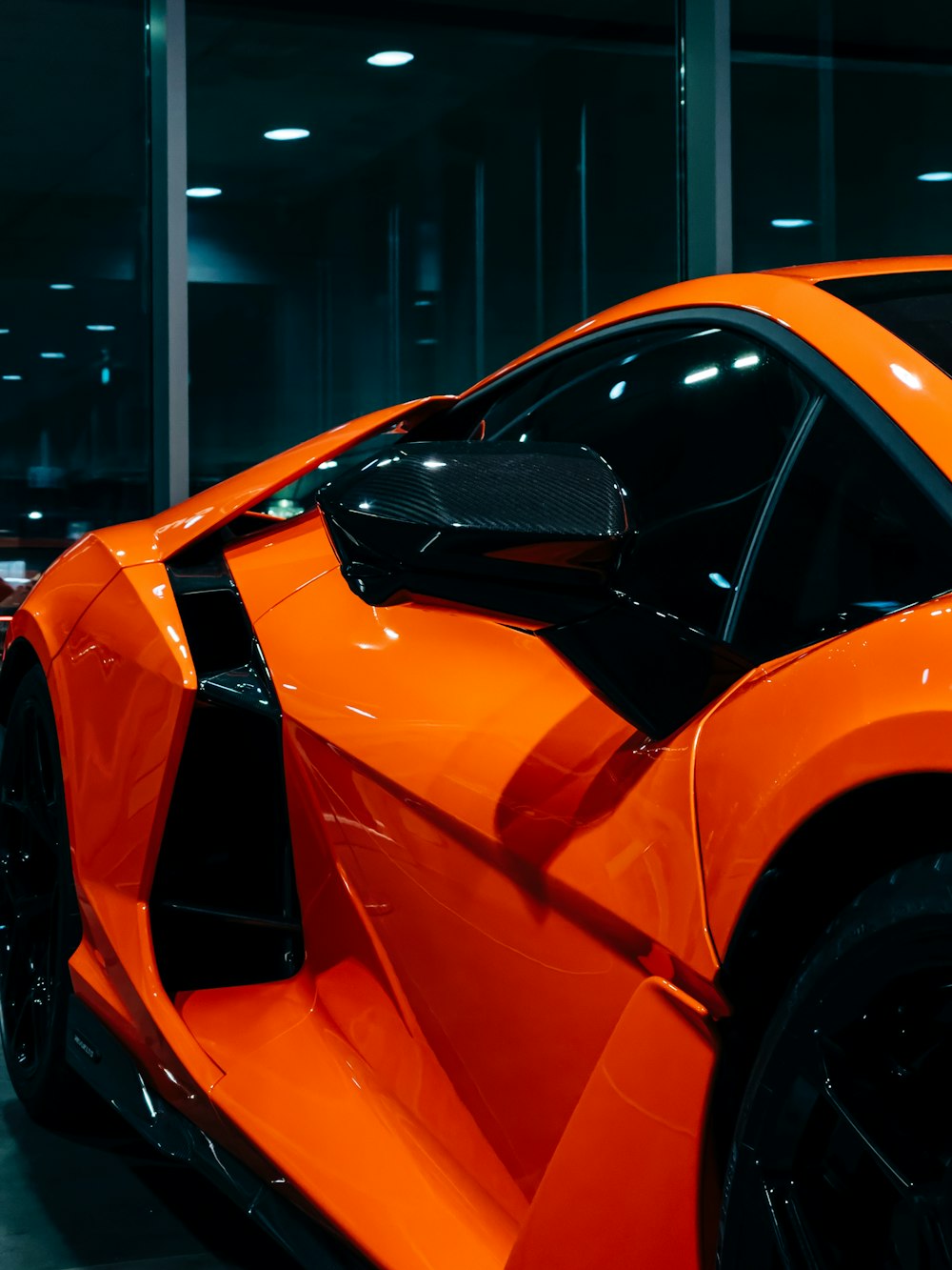 an orange sports car parked in a garage