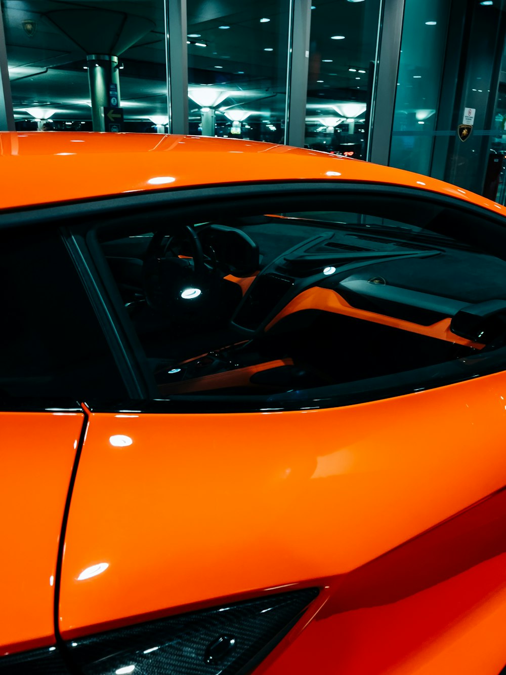 a bright orange sports car parked in a garage