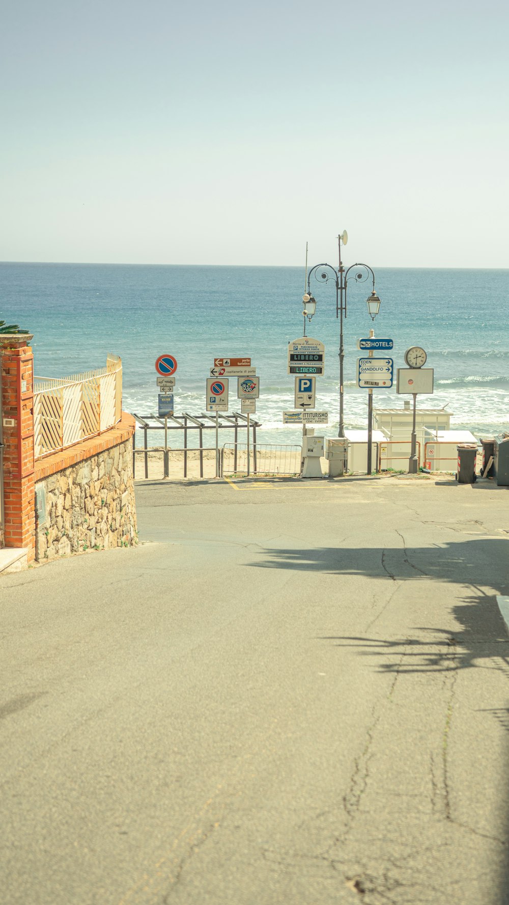 a street sign on the side of a road next to the ocean