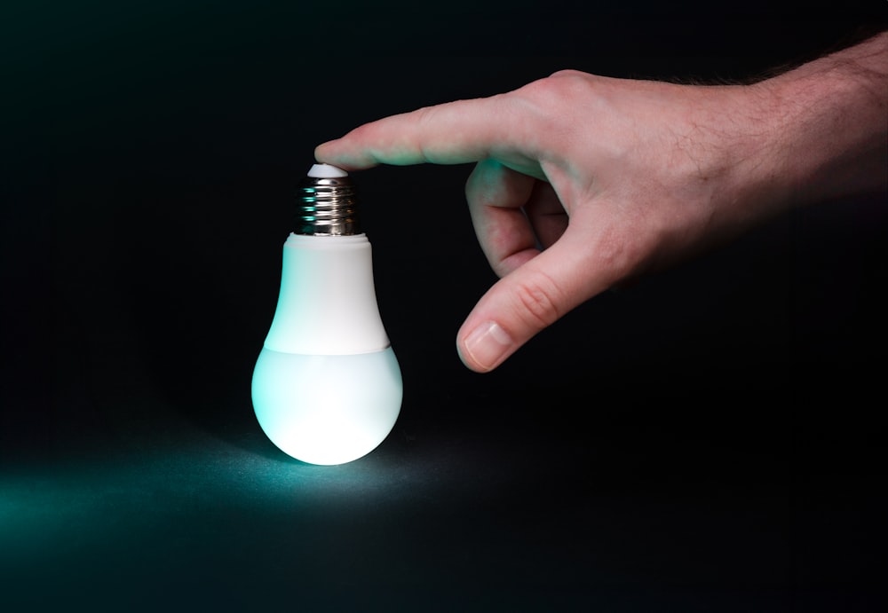 a light bulb being held by a hand