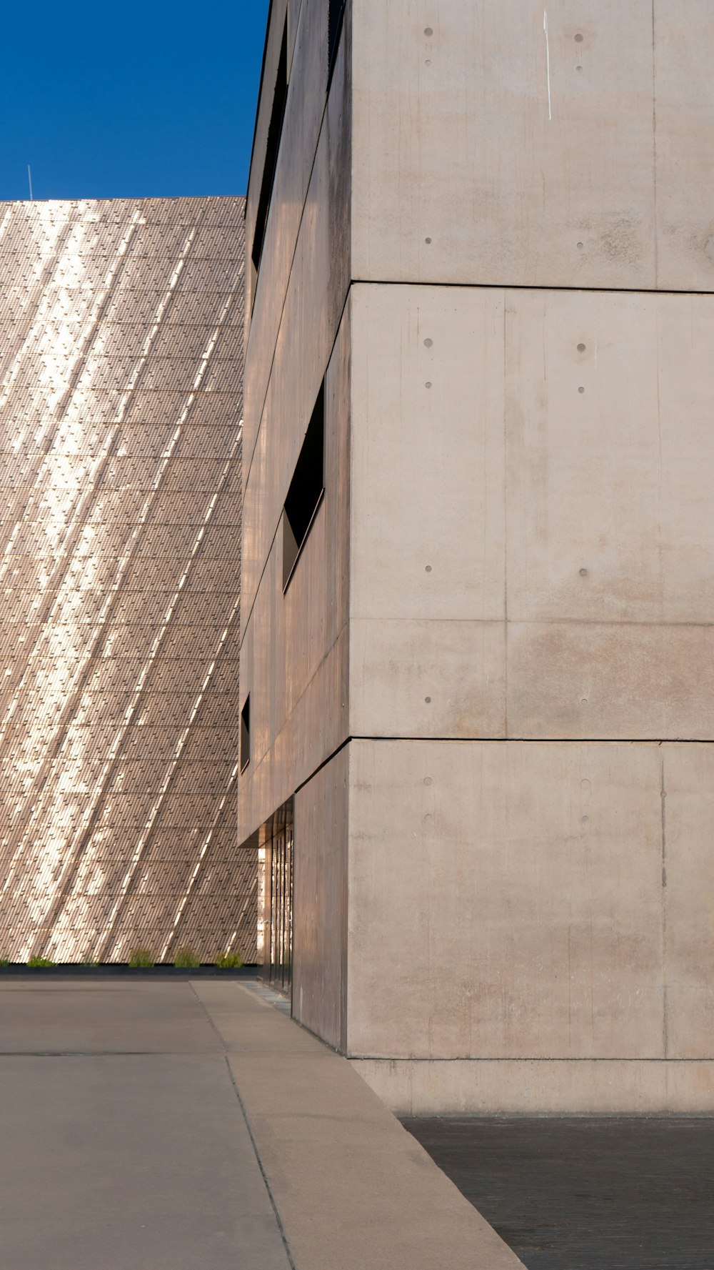 a man riding a skateboard down a sidewalk next to a tall building