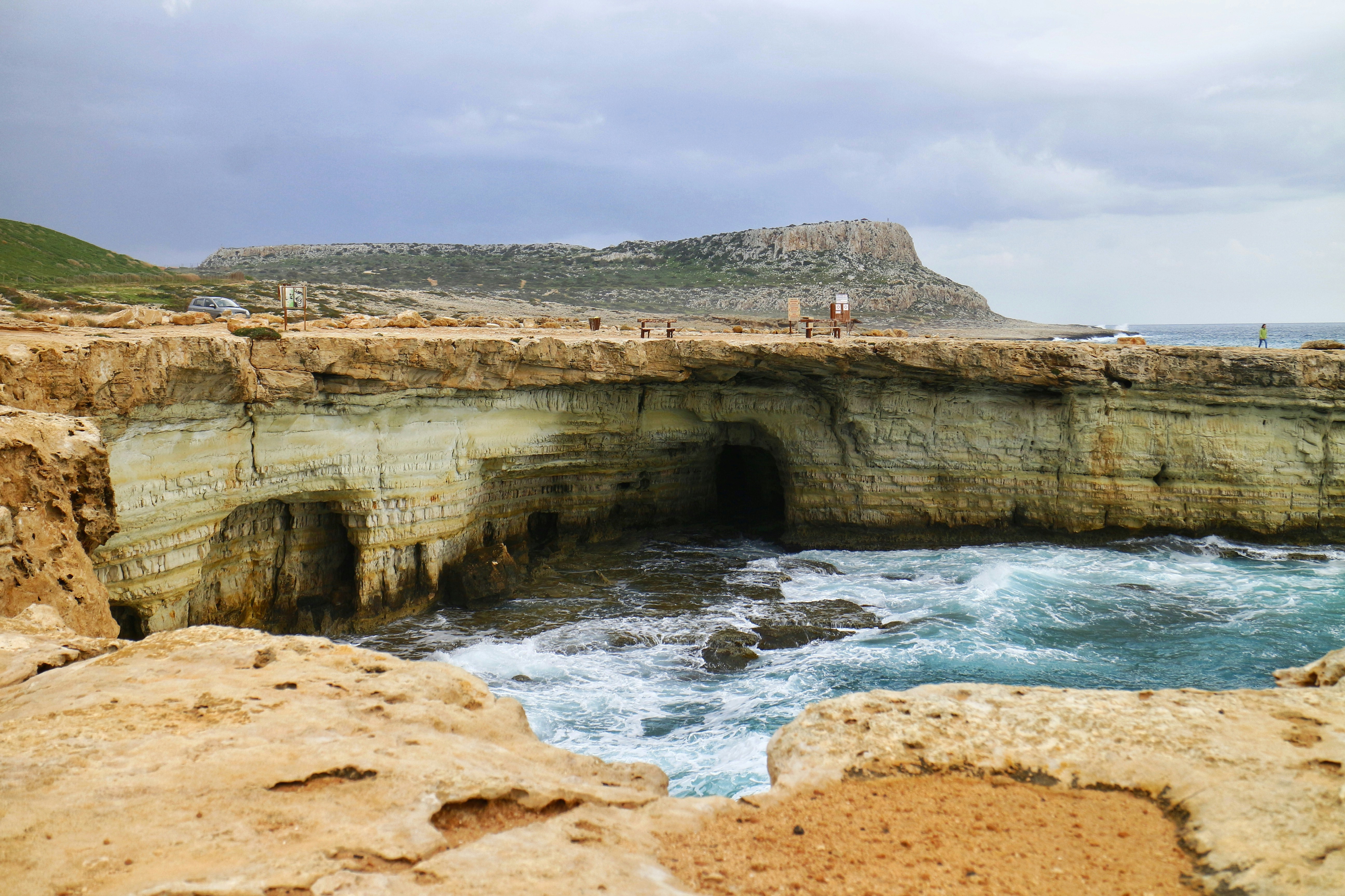 a group of people standing on top of a cliff near the ocean
