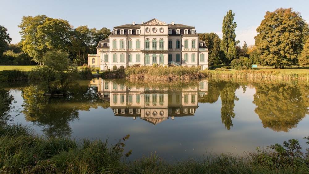 Una grande casa bianca seduta in cima a un lussureggiante campo verde