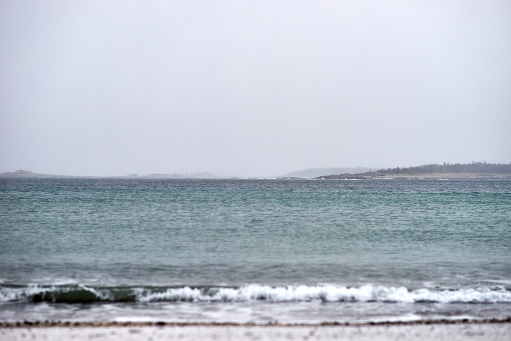 a large body of water sitting on top of a sandy beach