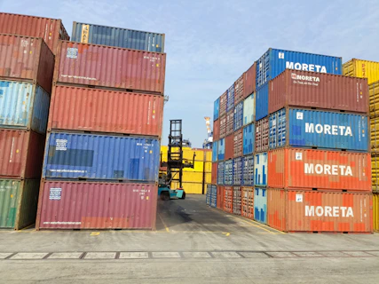 a forklift is moving a large stack of shipping containers