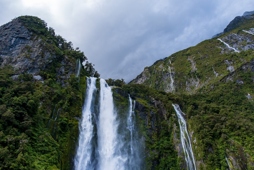 a large waterfall surrounded by lush green mountains