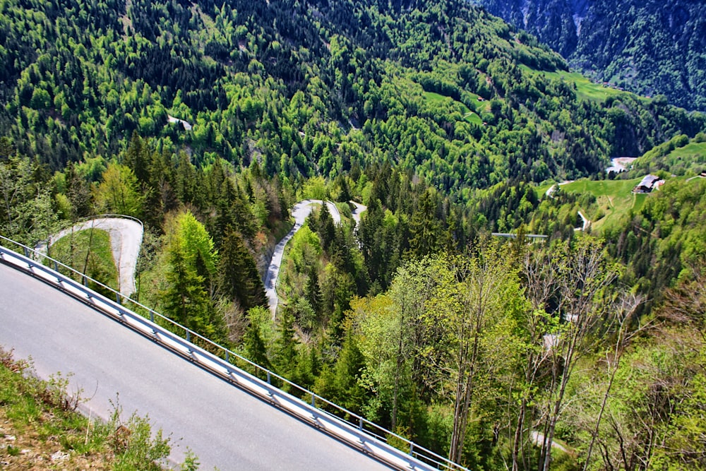 a winding road in the middle of a lush green valley