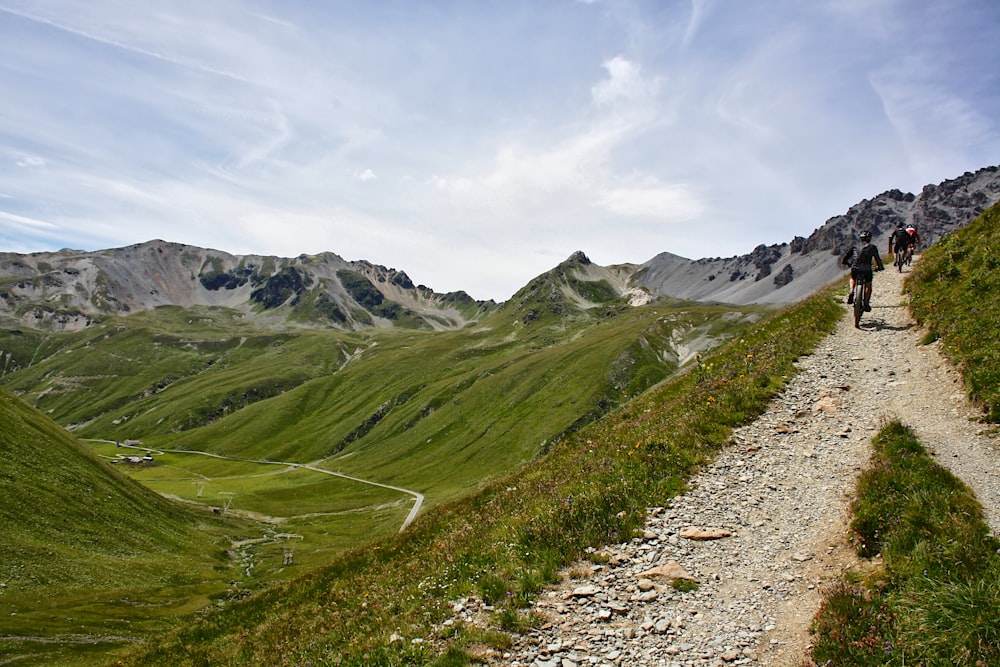 a couple of people walking down a dirt road