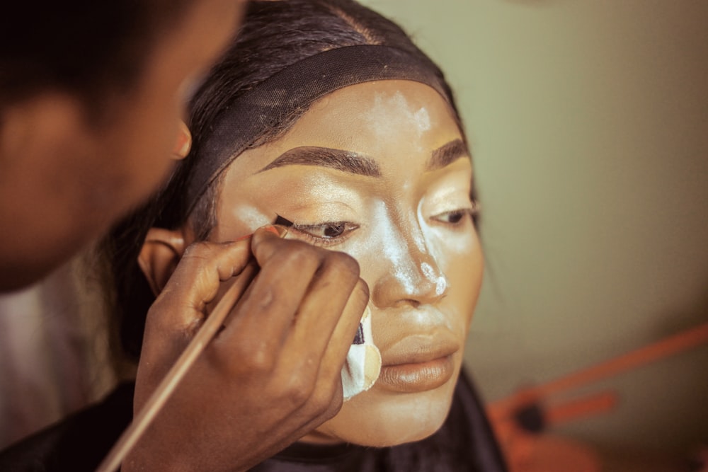 a woman is getting her make up done