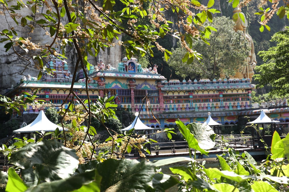 a colorfully painted building in the middle of a forest