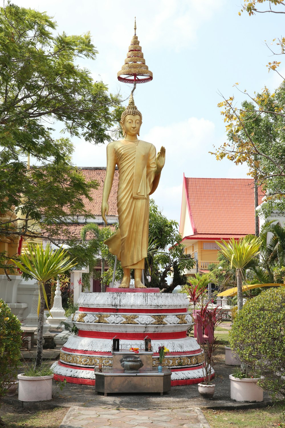 a large golden buddha statue in a garden