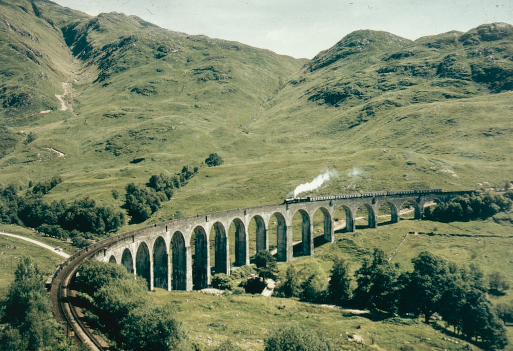 a train on a train track with mountains in the background