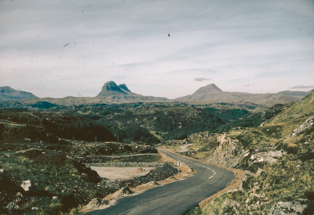 a winding road with a mountain in the background