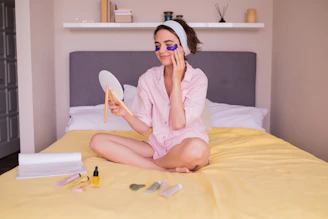 a woman sitting on a bed holding a mirror