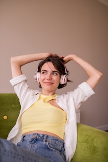a woman sitting on a couch wearing headphones