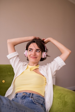 a woman sitting on a couch wearing headphones