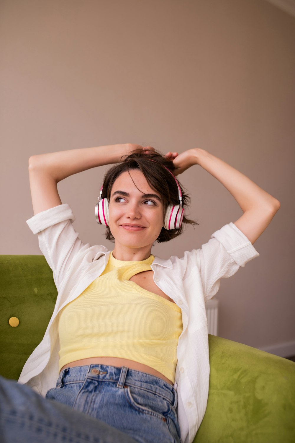 a woman sitting on a couch wearing headphones