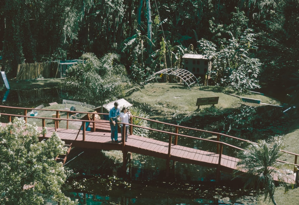 a group of people walking across a bridge