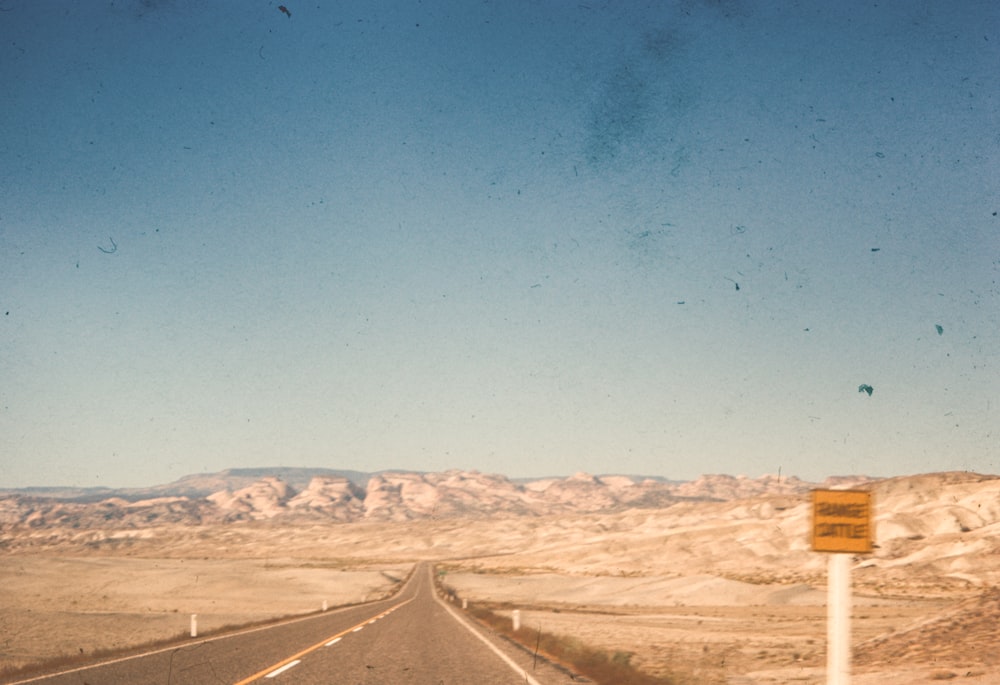 una carretera en medio de un desierto con montañas al fondo