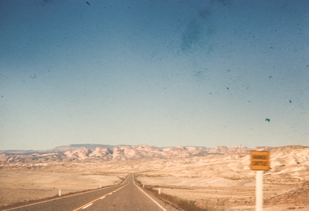 a road in the middle of a desert with mountains in the background