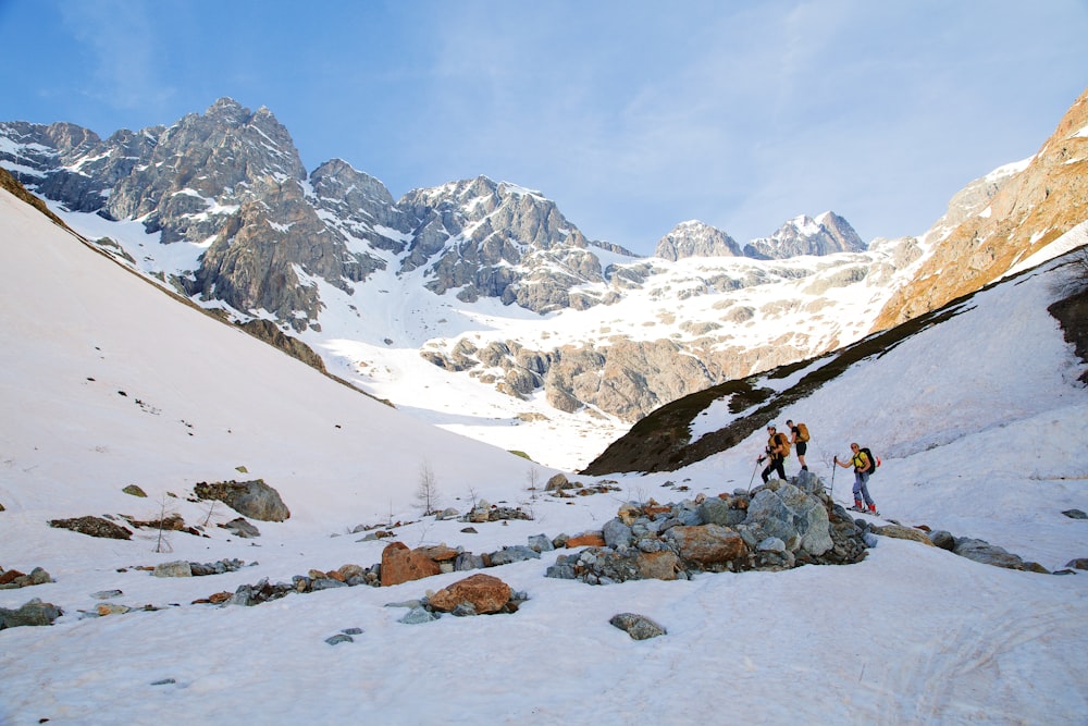 um grupo de pessoas caminhando por uma montanha coberta de neve