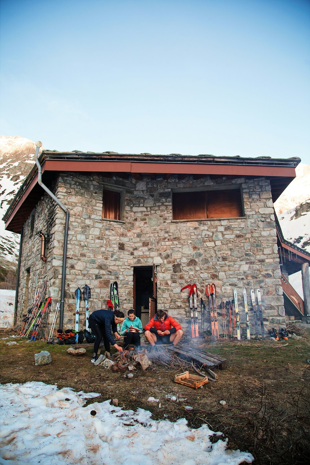 a group of people sitting around a fire in front of a building