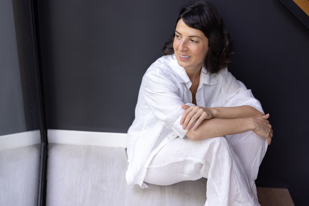 a woman sitting on the floor with her arms crossed