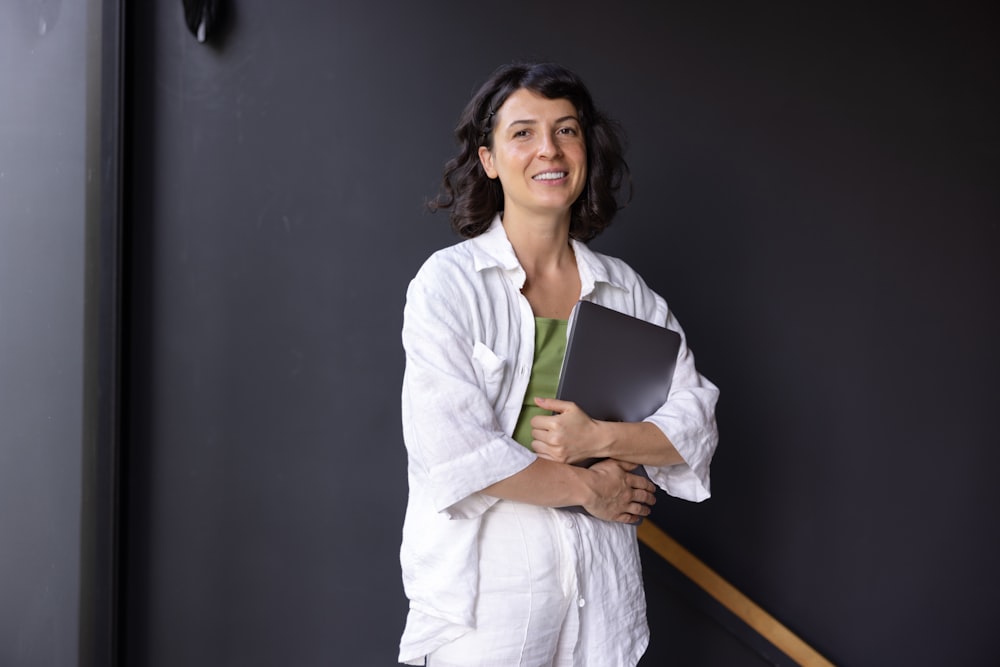 a woman in a white shirt is holding a folder