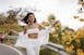 a woman in a white outfit is walking down a road